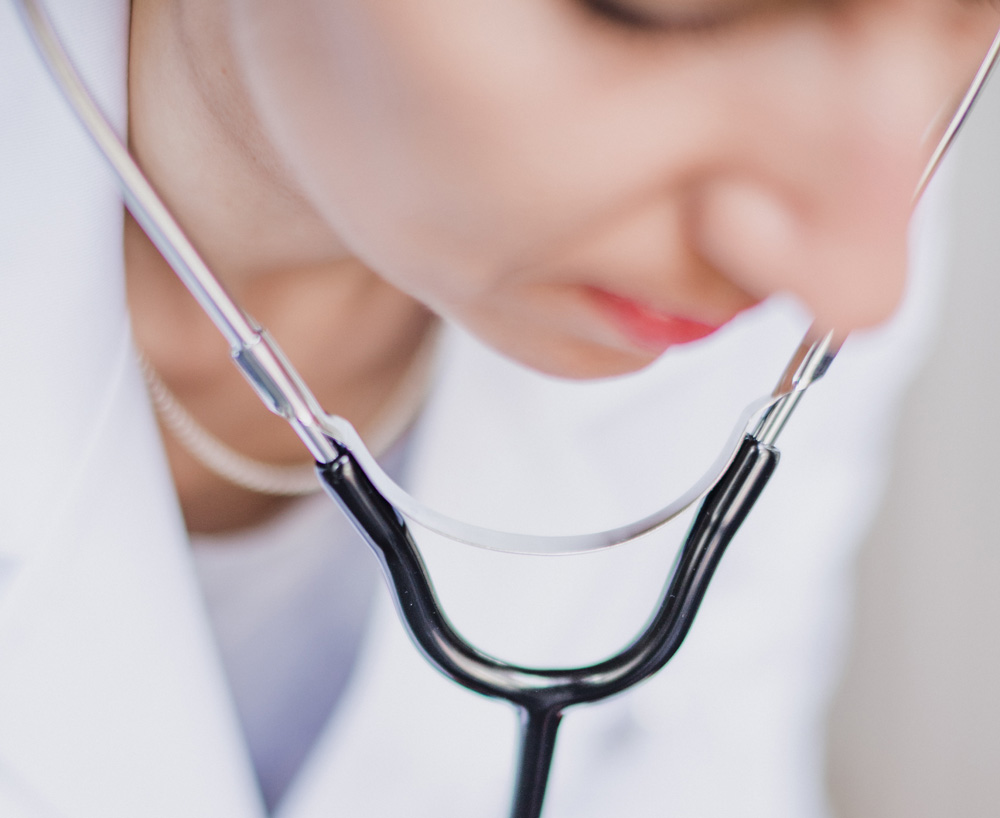 Clinician 2b Clinician with stethoscope around their neck leaning forward